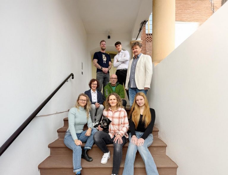 Das Team der WEGEHAUPT Gruppe sitzt gemeinsam auf einer Außentreppe.